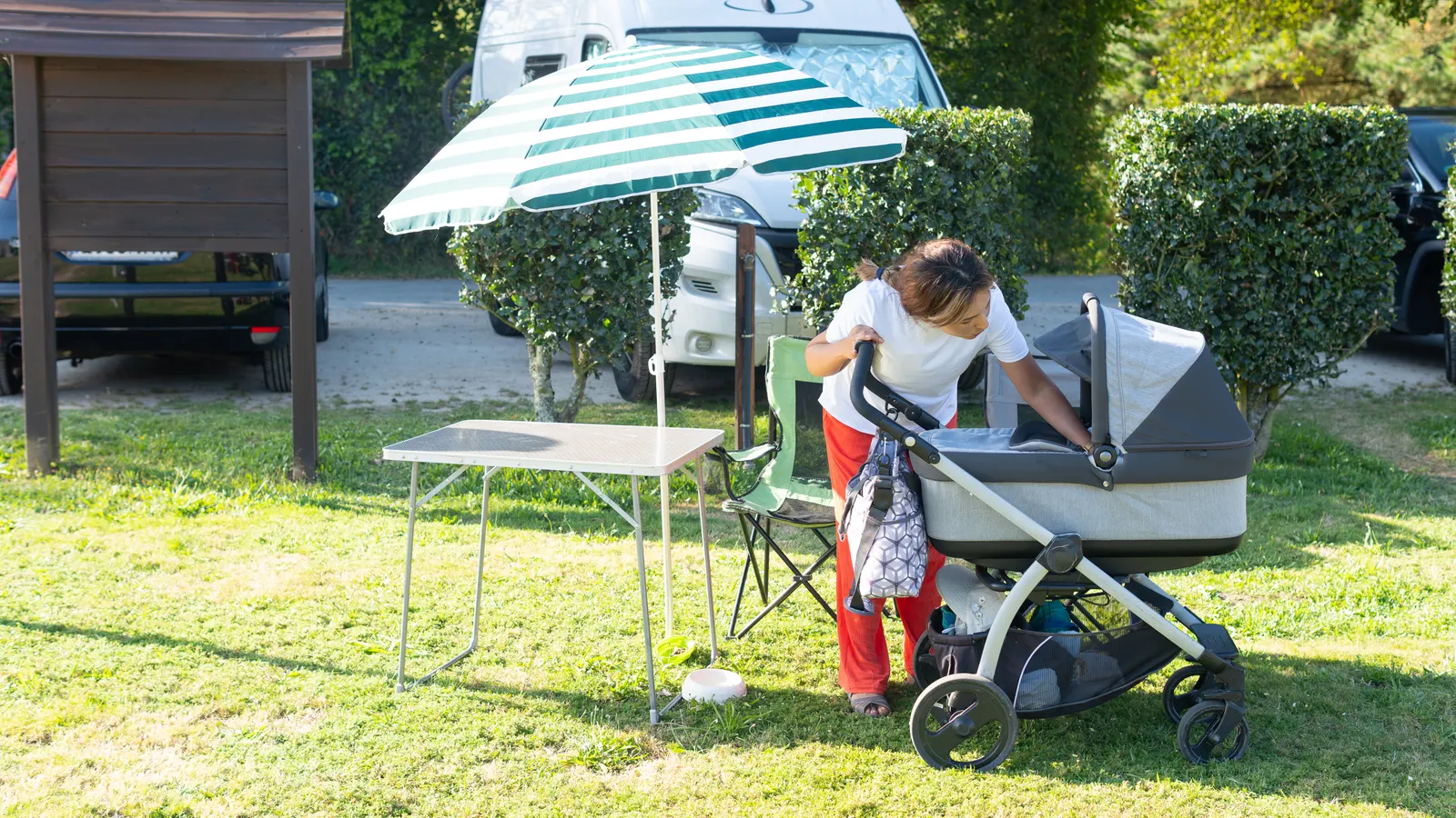 Barnvagn med parasoll i sommarsol